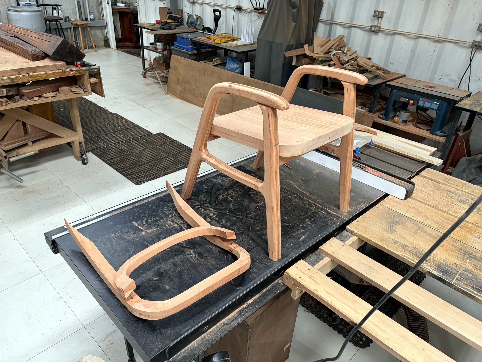 The organic chair design taking shape in the shop, joinery and arm details visible.